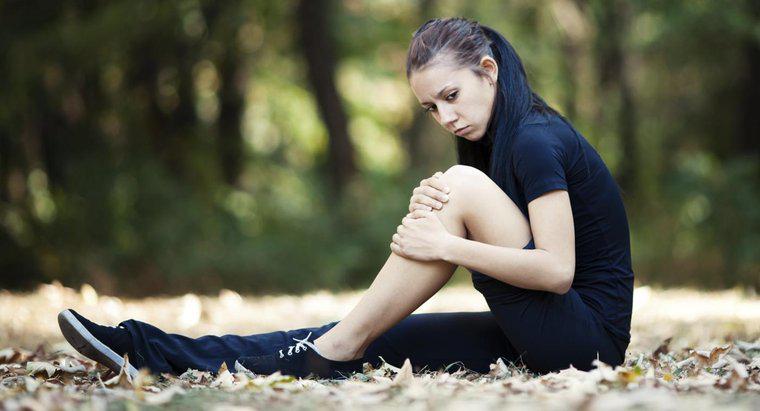 Quais são algumas das possíveis causas de fraqueza e dor muscular nas pernas?